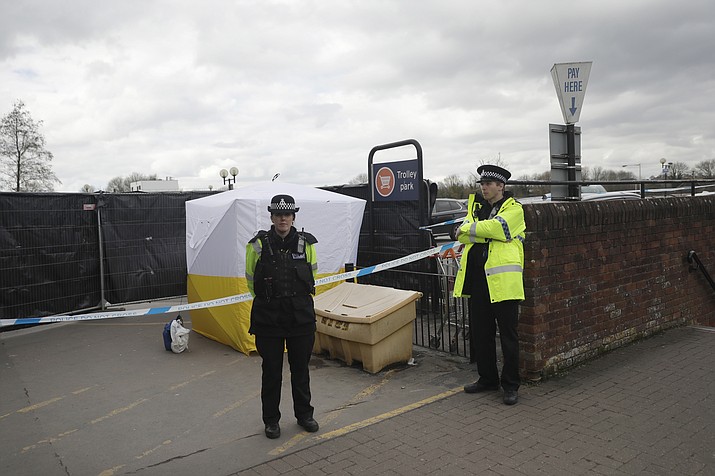 In this March 13, 2018, file photo, police officers guard a cordon around a police tent covering a supermarket car park pay machine near the spot where former Russian spy Sergei Skripal and his daughter were found critically ill following exposure to the Russian-developed nerve agent Novichok in Salisbury, England. The United States will impose sanctions on Russia for the country’s use of a nerve agent in an assassination attempt on a former Russian spy and his daughter. (Matt Dunham/AP, File)