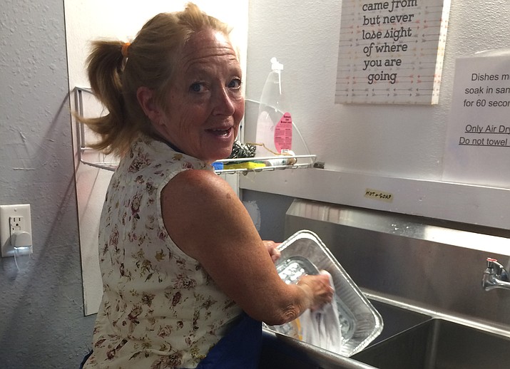 Coalition of Compassion and Justice volunteer Doretta Kearney, 63, of Prescott, washes dishes in the shelter facility on Madison Avenue in Prescott. (Nanci Hutson/Courier)