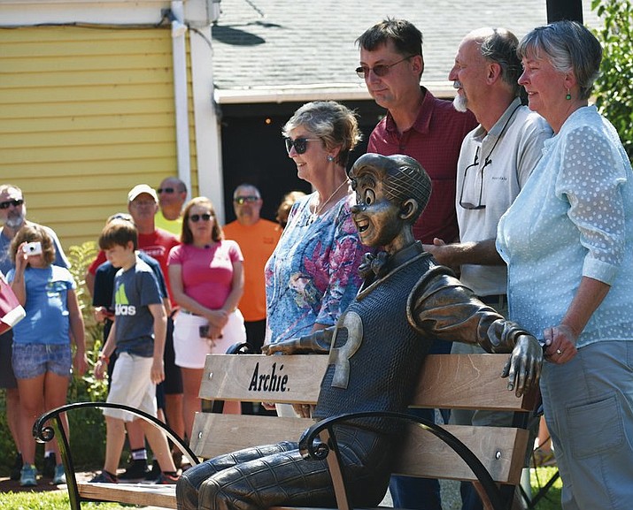 A statue of the comic strip character Archie sits on a park bench, created by sculptor Valery Mahuchy, as it was unveiled in Community Park, Meredith, Thursday, Aug. 9, 2018, as part of the town’s 250th anniversary celebration. Archie illustrator Bob Montana lived in Meredith for 35 years and worked many local residents and scenes into the comic strip until his death in 1975 at age 54. Posing with the statue are Montana’s children, Paige, Donald, Raymond, and Lynn. (Tom Caldwell/Laconia Daily Sun via AP)

