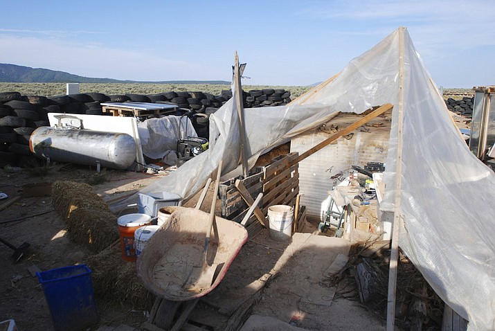 Various items litter a squalid makeshift living compound in Amalia, N.M., on Friday, Aug. 10, 2018, where five adults were arrested on child abuse charges and remains of a boy were found. The remains, which haven't been positively identified, may resolve the fate of Abdul-ghani Wahhaj, a missing, severely disabled Georgia boy. Eleven other children were found at the compound during a raid last week. (AP Photo/Morgan Lee)

