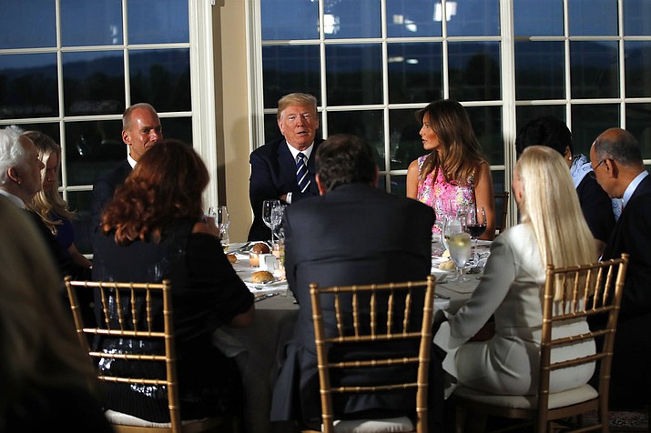President Donald Trump sits with first lady Melania Trump as he meets with business leaders, Tuesday, Aug. 7, 2018, at Trump National Golf Club in Bedminster, N.J. (AP Photo/Carolyn Kaster)

