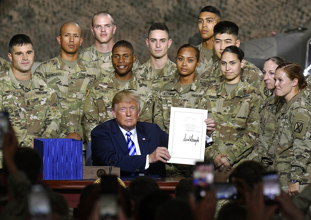 President Donald Trump signs the John McCain National Defense Authorization Act for the Fiscal Year 2019, during a signing ceremony Monday, Aug. 13, 2018, in Fort Drum, N.Y. (AP Photo/Hans Pennink)