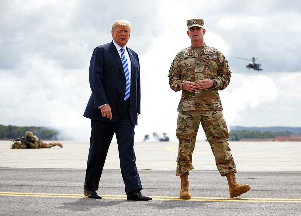 President Donald Trump and Maj. Gen. Walter Piatt walk as they view air assault exercises at Fort Drum, N.Y., Monday, Aug. 13, 2018, before a signing ceremony for a $716 billion defense policy bill named for Sen. John McCain. (AP Photo/Carolyn Kaster)