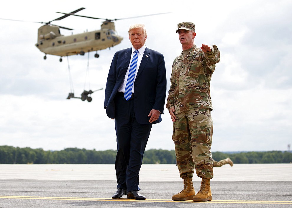 President Donald Trump and Maj. Gen. Walter Piatt view air assault exercises at Fort Drum, N.Y., Monday, Aug. 13, 2018, before a signing ceremony for a $716 billion defense policy bill named for Sen. John McCain. (AP Photo/Carolyn Kaster)