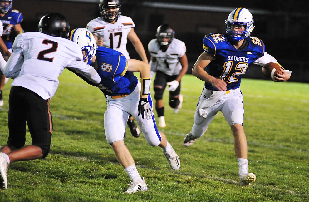 Prescott's Austin Clark with a lead block by Jacob Gilpin heads upfield for a long gain as the Badgers take on Desert Edge Friday August 17, 2018 to open the 2018 football season. (Les Stukenberg/Courier)