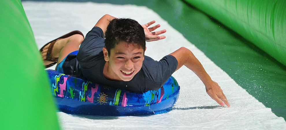 Kenji Acor from Las Vegas comes down the 600+ foot water slide at the Monsoon Festival in downtown Prescott Saturday, August 18, 2018.  (Les Stukenberg/Courier)