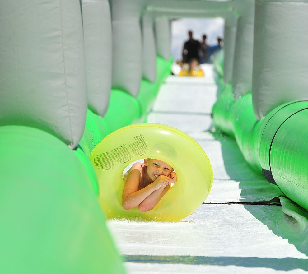 Nine year old Logan Eyler comes down the 600+ foot water slide at the Monsoon Festival in downtown Prescott Saturday, August 18, 2018.  (Les Stukenberg/Courier)