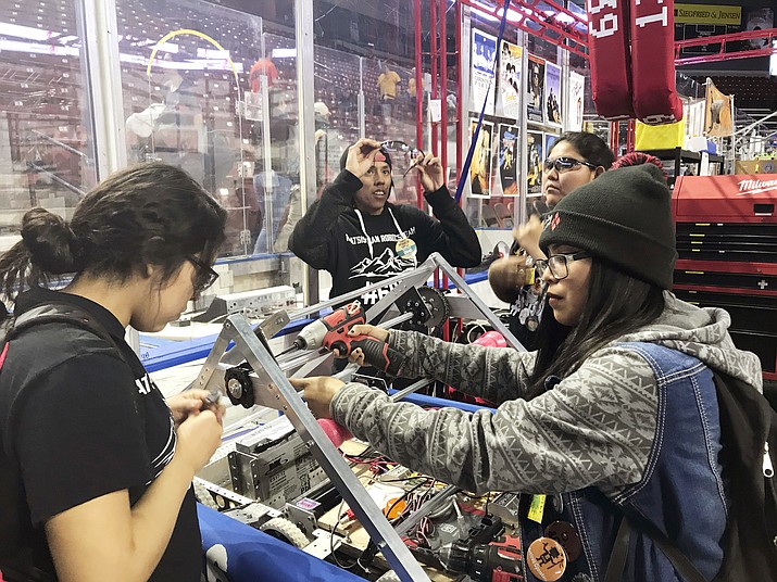 Navajo Mountain High School students Nahida Smith, Myra King and Breana Bitsinne compete in a Utah regional robotics competition in West Valley City, Utah. The team headed to an international robotics competition Aug. 14 in Mexico City, Mexico. They were invited to compete in the First Global Challenge, which draws teams from 190 countries to create robots capable of feeding power plants and building environmentally efficient transmission networks. (Heather Anderson via AP) 