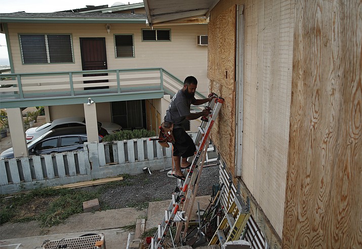Kaipo Popa secures plywood to protect windows on a home in preparation for Hurricane Lane, Wednesday, Aug. 22, 2018, in Kapolei, Hawaii. As emergency shelters opened, rain began to pour and cellphone alerts went out, the approaching hurricane started to feel real for Hawaii residents. (John Locher/AP)