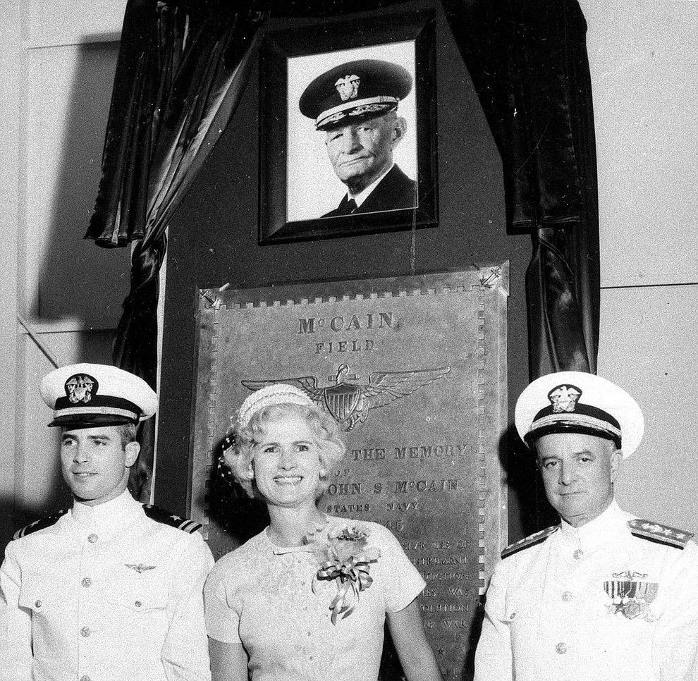 FILE - In this July 14, 1961, file photo, U.S. Navy Lt. John S. McCain III, left, and his parents, Rear Adm. John S. McCain Jr., right, and Roberta Wright McCain stand in front of a plaque with an image of his grandfather, Adm. John S. McCain, as the Naval Air Station Meridian McCain Field is commissioned and named in honor of Adm. McCain in Meridian, Miss. An aide says that U.S. Sen. John McCain died Saturday, Aug. 25, 2018. He was 81. (AP Photo/File)