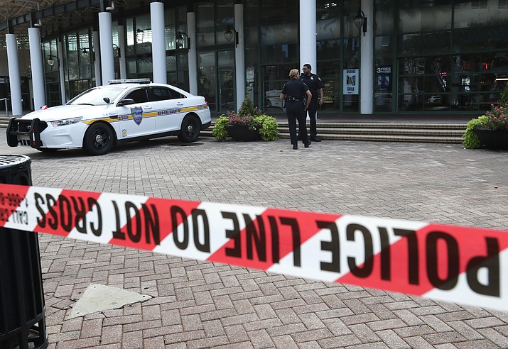 Jacksonville police officers guard an area Monday, Aug. 27, 2018, near the scene of a fatal shooting at The Jacksonville Landing on Sunday in Jacksonville, Fla. (AP Photo/John Raoux)