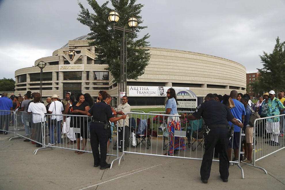 Detroit police help with a barricade at the Charles H. Wright Museum of African American History where fans line up to pay their final respects to Aretha Franklin, Tuesday, Aug. 28, 2018, in Detroit. (AP Photo/Carlos Osorio)