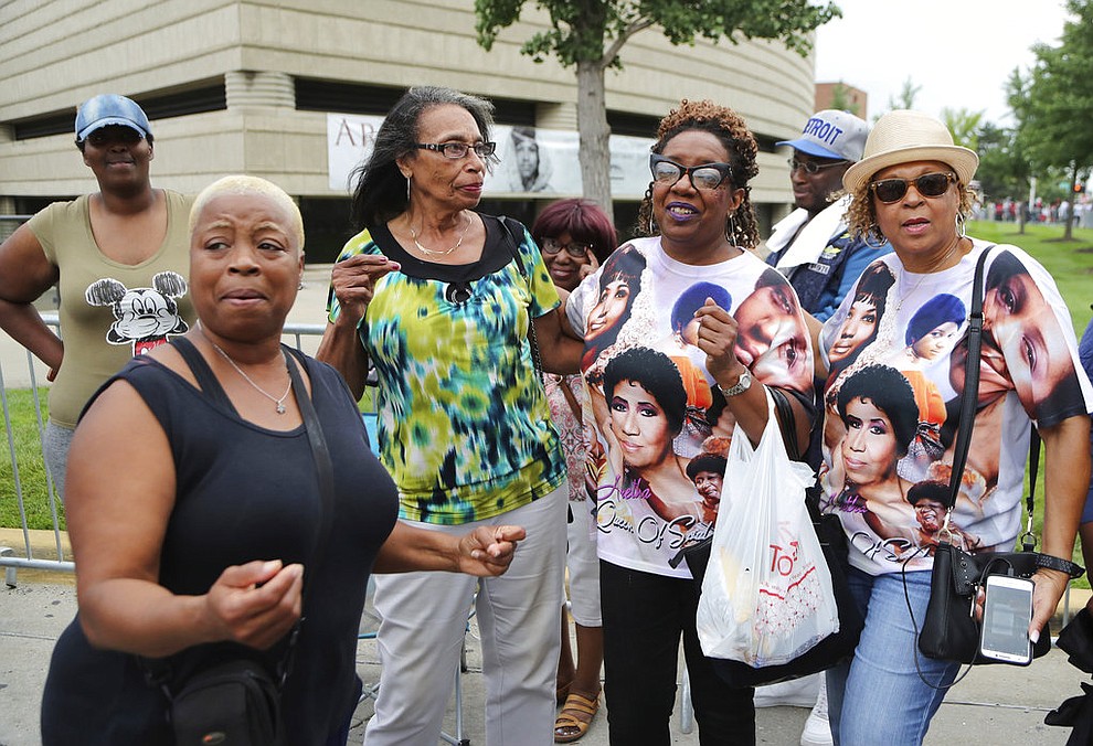 From left, Felicia Phillips, Alice Howard, Rochelle Hampton and Imogene King-Dugan sing as they wait in line at the Charles H. Wright Museum of African American History to pay their final respects to Aretha Franklin, Tuesday, Aug. 28, 2018, in Detroit. (AP Photo/Carlos Osorio)