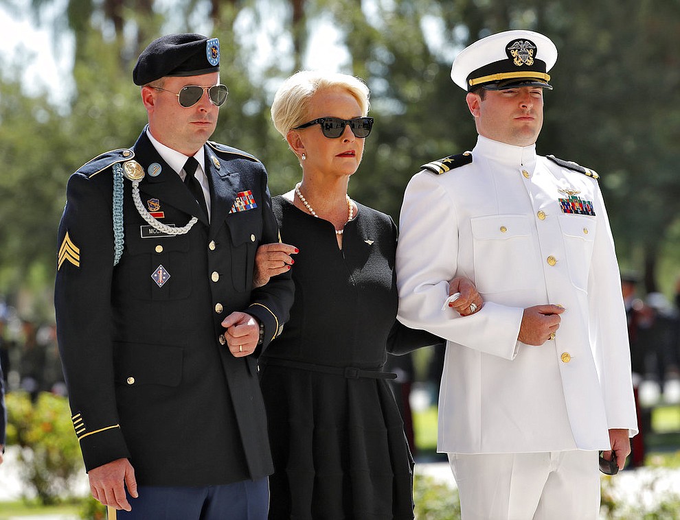 Cindy McCain, escorted by sons, Jack McCain, right, and Jimmy McCain, follow behind military personal carrying the casket of Sen. John McCain, R-Ariz., into the Capitol rotunda for a memorial service, Wednesday, Aug. 29, 2018, at the Capitol in Phoenix. (AP Photo/Matt York)
