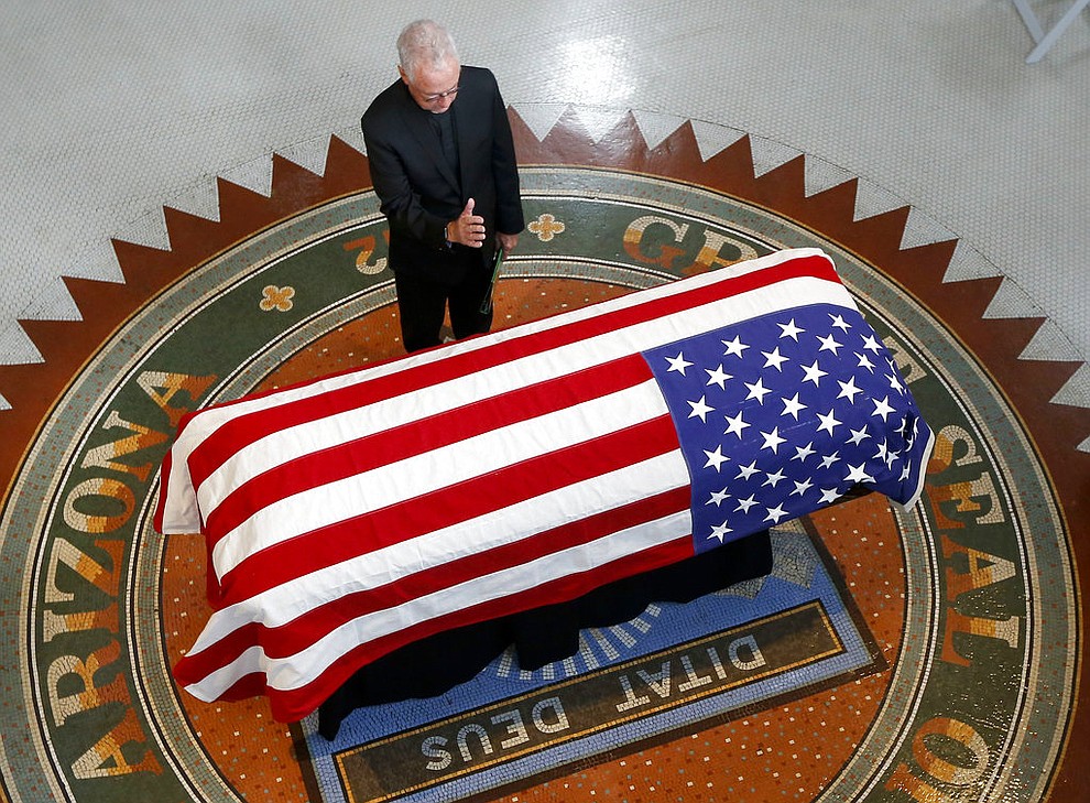 Father Edward A. Reese prays over the casket during a memorial service for Sen. John McCain, R-Ariz. at the Arizona Capitol on Wednesday, Aug. 29, 2018, in Phoenix. (AP Photo/Ross D. Franklin, Pool)