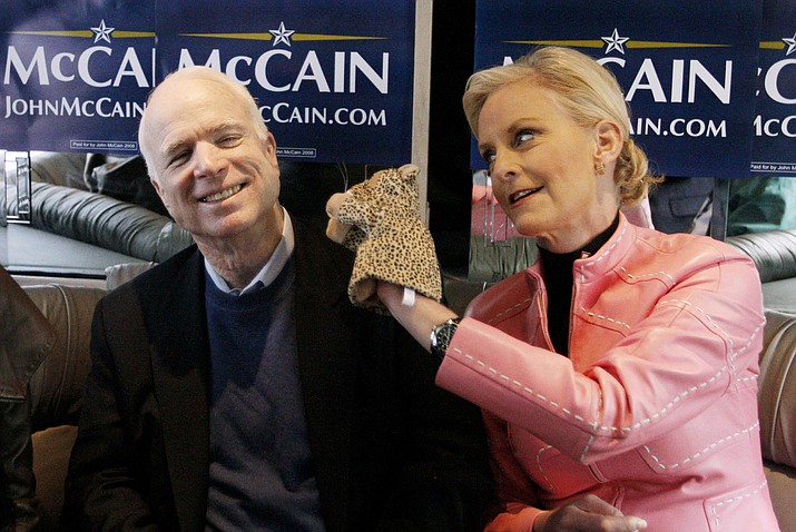 In this Jan. 19, 2008, file photo, Cindy McCain, wife of Republican presidential hopeful Sen. John McCain, R-Ariz., uses a cheetah hand puppet to make her husband laugh as they ride the "Straight Talk Express" campaign bus to a polling station in Charleston, S.C. McCain's funeral was Thursday, Aug. 30, 2018. He was 81. (Charles Dharapak/AP, File)

