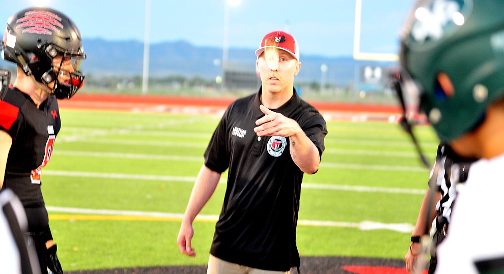 Granite Mountain Hotshot Brendan McDonough flips the coin before Bradshaw Mountain take on the Youngker Roughriders in their home opener Friday, August 31, 2018 in Prescott Valley. (Les Stukenberg/Courier)