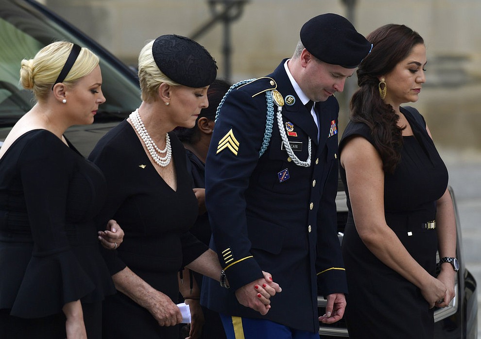 From left, Meghan McCain, Cindy McCain, Jimmy McCain and his wife Holly pause as they watch the casket of Sen. John McCain, R-Ariz., arrive at the Washington National Cathedral in Washington, Saturday, Sept. 1, 2018, for a memorial service. McCain died Aug. 25 from brain cancer at age 81. (AP Photo/Susan Walsh)