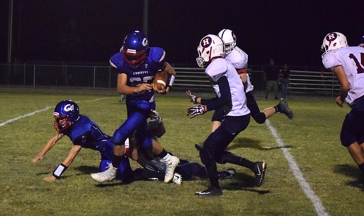 Camp Verde junior Cale Cook runs through the Hero defense during the Cowboys’ 24-0 win over Heritage Academy Laveen on Friday night at home. CV ran for 397 yards with Cook gaining 133. VVN/James Kelley
