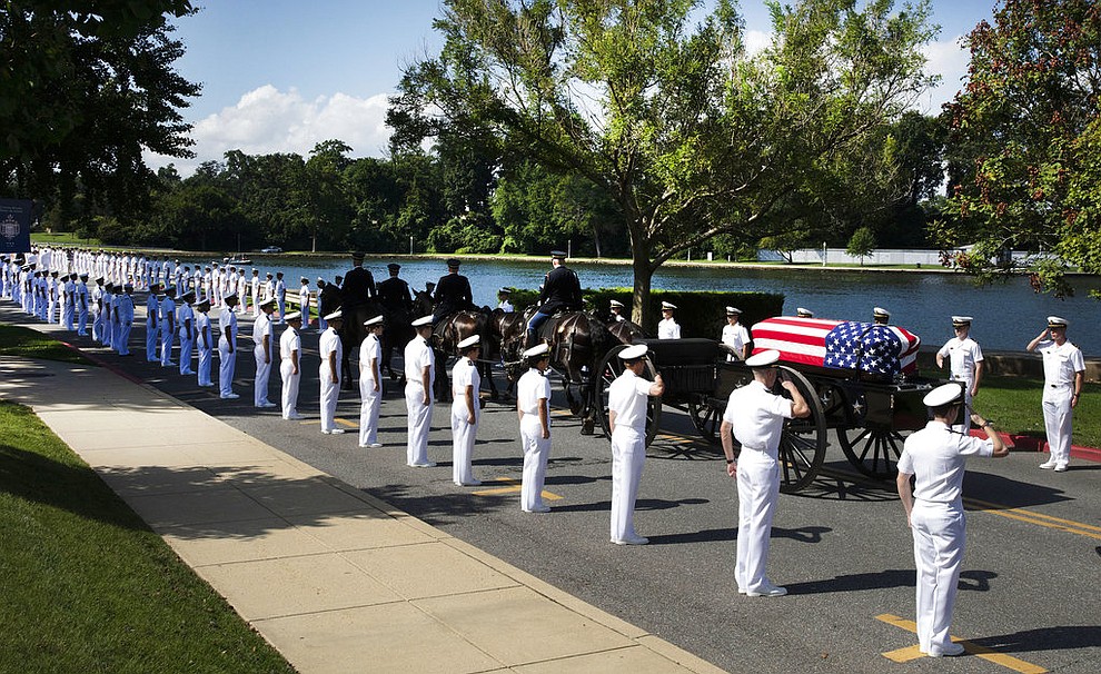 In this photo provided by the family of John McCain, the horse-drawn caisson bearing the body of Sen. John McCain, R-Ariz., moves through the grounds of the United Sates Naval Academy toward the cemetery after a service in the Chapel Sunday, Sept. 2, 2018, in Annapolis, Md. (David Hume Kennerly/McCainFamily via AP)