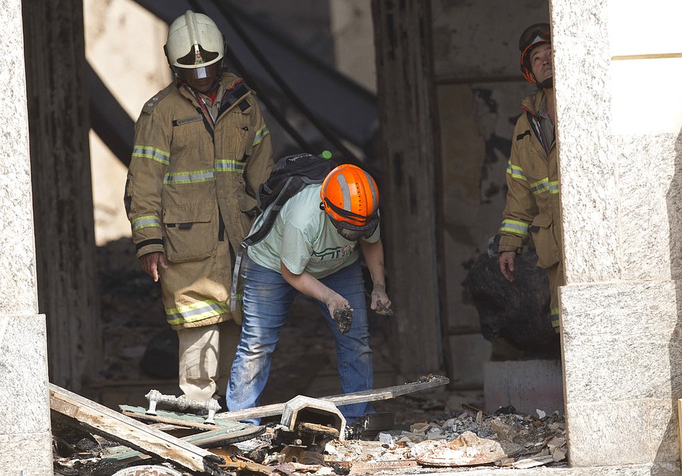 A National Museum worker inspects the charred rubble after an overnight fire at the museum in Rio de Janeiro, Brazil, Monday, Sept. 3, 2018. The esteemed museum houses artifacts from Egypt, Greco-Roman art and some of the first fossils found in Brazil. (AP Photo/Silvia Izquierdo)