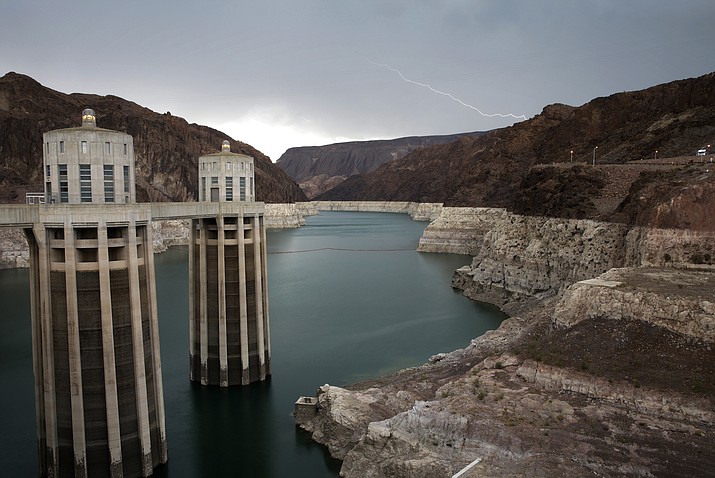 In this July 28, 2014 file photo, lightning strikes over Lake Mead near Hoover Dam at the Lake Mead National Recreation Area in Arizona. Water levels at Lake Mead and Lake Powell are dropping to dangerous levels, reflecting the Colorado River's worsening "structural deficit," scientists said. Scientists from the Colorado River Research Group said Lake Powell has declined because of extra water releases flowing into Lake Mead, the Arizona Republic reported Aug. 28, 2018. (John Locher/AP, file)