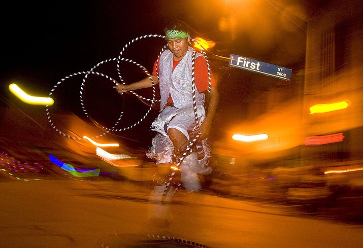 A 2010 file photo shows a hoop dancer wowing a crowd in downtown Gallup as part of the Gallup Inter-Tribal Indian Ceremonial night parade. Gallup surrounded by Navajo culture and Native arts and crafts is experiencing a tourism boom not seen since the 1970s. (Aaron Gardner/The Gallup Independent via AP)