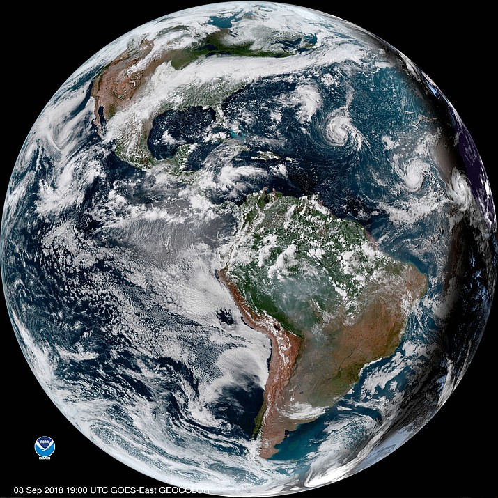 This enhanced satellite image made available by NOAA shows Tropical Storm Florence, third from right, in the Atlantic Ocean on Saturday, Sept. 8, 2018 at 3 p.m. EDT. At right, off the coast of Africa is Tropical Storm Helene, and second from right is Tropical Depression 9. (NOAA via AP)