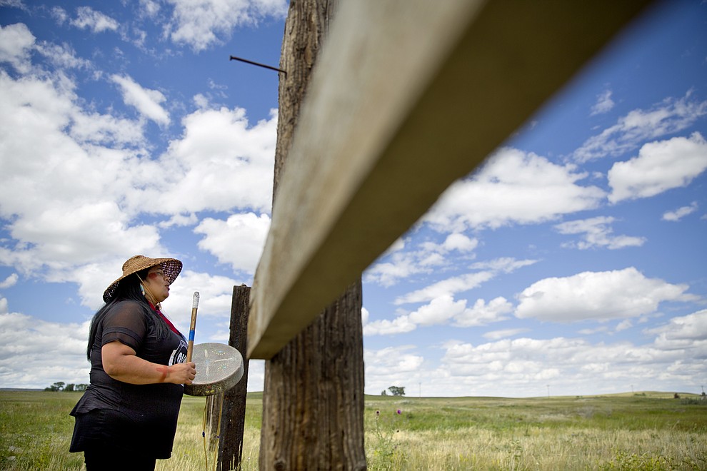 Roxanne White, whose aunt was murdered in 1996, sings and drums a women's warrior and honor song created for missing and murdered indigenous women, before joining a search in Valier, Mont., for Ashley HeavyRunner Loring, who disappeared last year from the Blackfeet Indian Reservation, Wednesday, July 11, 2018. For many in Native American communities across the nation, the problem of missing and murdered women is deeply personal. (AP Photo/David Goldman)