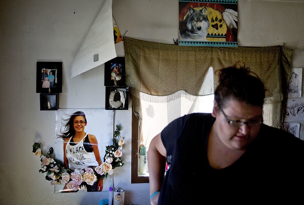 A poster of Ashley HeavyRunner Loring hangs on the wall as her sister, Kimberly, walks through her room at their grandmother's home on the Blackfeet Indian Reservation in Browning, Mont., Friday, July 13, 2018. Kimberly was 8 when she made a promise to Ashley, then 5, while the girls were briefly in a foster home. "'We have to stick together,'" she'd said to her little sister. "I told her I would never leave her. And if she was going to go anywhere, I would find her." (AP Photo/David Goldman)