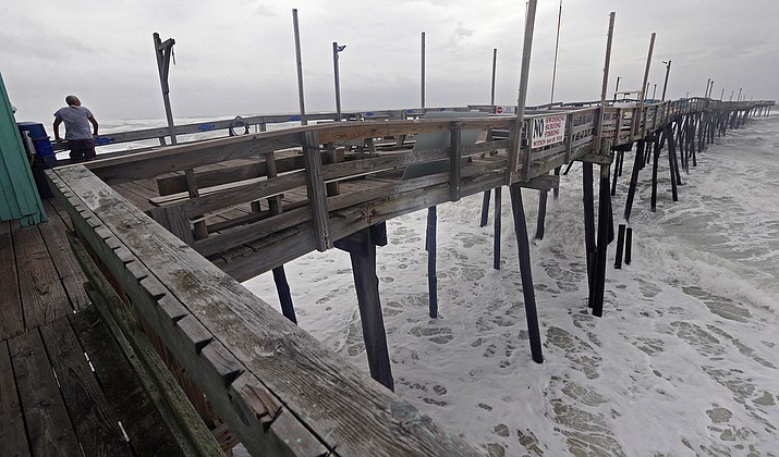 Waves crash under the Avalon Fishing Pier in Kill Devil Hills, N.C., Thursday, Sept. 13, 2018 as Hurricane Florence approaches the east coast. (AP Photo/Gerry Broome)