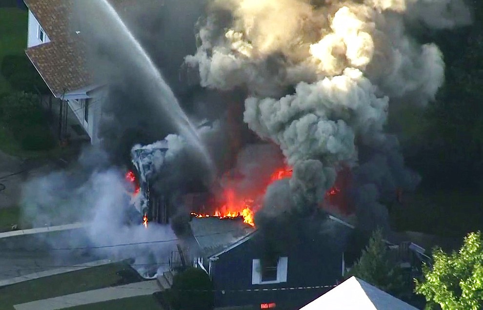 In this image take from video provided by WCVB in Boston, flames consume the roof of a home in Lawrence, Mass, a suburb of Boston, Thursday, Sept. 13, 2018. A series of gas explosions killed a teenager, injured at least 10 other people and ignited fires in at least 39 homes in three communities north of Boston, forcing entire neighborhoods to evacuate as crews scrambled to fight the flames and shut off the gas. (WCVB via AP)