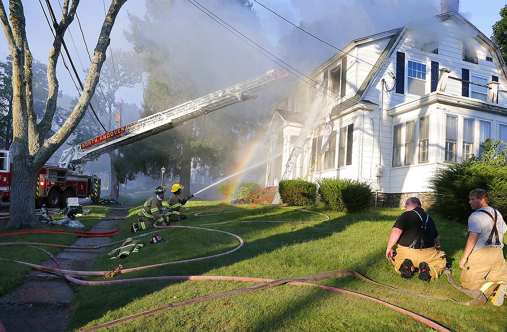 Firefighters battle a house fire, Thursday, Sept. 13, 2018, on Herrick Road in North Andover, Mass., one of multiple emergency crews responding to a series of gas explosions and fires triggered by a problem with a gas line that feeds homes in several communities north of Boston. (AP Photo/Mary Schwalm)