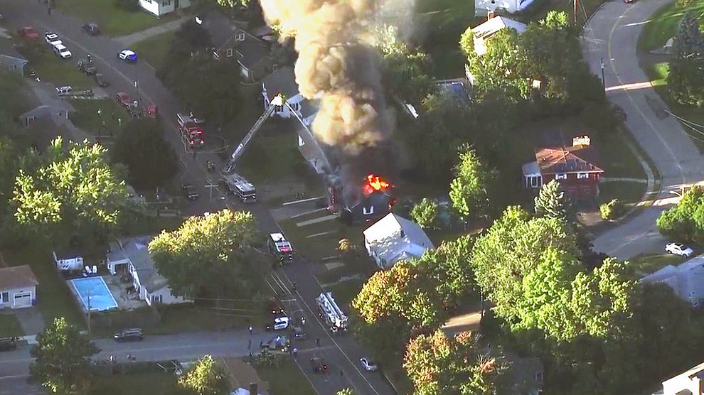 In this image take from video provided by WCVB in Boston, firefighters battle a raging house fire in Lawrence, Mass, a suburb of Boston, Thursday, Sept. 13, 2018. Emergency crews responded to what they believe is a series of gas explosions that have damaged homes across three communities north of Boston. (WCVB via AP)
