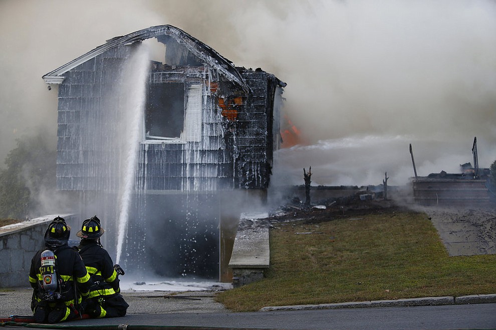 Crews work to knock down a fire in Lawrence, Mass., Thursday, Sept. 13, 2018. The company that owns Columbia Gas says its crews are performing safety checks after a series of fires and explosions erupted in three communities north of Boston. Authorities are blaming over-pressurized gas lines and previously told all residents with Columbia Gas service in those areas to evacuate. (Jessica Rinaldi/The Boston Globe via AP)