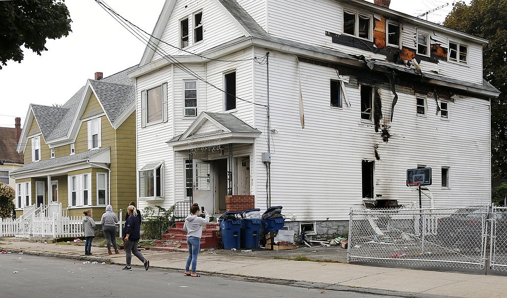 Lawrence residents stop to take photos of a house on Bowdoin Street in Lawrence Mass., Friday, Sept. 14, 2018. The home was one of multiple houses that went up in flames on Thursday afternoon after gas explosions and fires triggered by a problem with a gas line that feeds homes in several communities north of Boston (AP Photo/Mary Schwalm)
