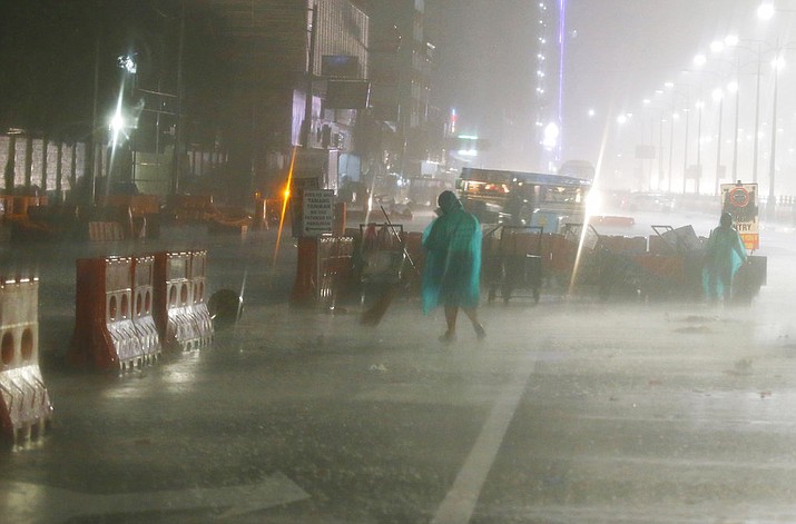 Street sweepers go about their daily business amidst the rain and strong winds brought about by Typhoon Mangkhut which barrelled into northeastern Philippines before dawn Saturday, Sept. 15, 2018 in Manila, Philippines. Typhoon Mangkhut, the strongest typhoon to hit the country this year, slammed into the country's northeastern coast early Saturday that forced the evacuation of thousands of residents. (AP Photo/Bullit Marquez)