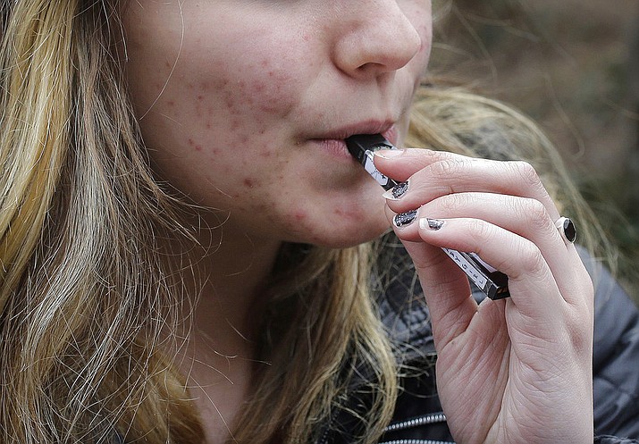 In this April 11, 2018, file photo, an unidentified 15-year-old high school student uses a vaping device near the school's campus in Cambridge, Mass. A school-based survey shows nearly 1 in 11 U.S. students have used marijuana in electronic cigarettes, heightening concern about the new popularity of vaping among teens. E-cigarettes typically contain nicotine, but results published Monday, Sept. 17, mean a little more than 2 million middle and high school students have used the devices to get high. (AP Photo/Steven Senne, File)

