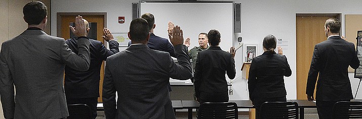 In this July 31, 2017, file photo, Yuma Sector Border Patrol Chief Patrol Agent Anthony Porvaznik, center, administers the oath to prospective U.S. Border Patrol agents at the Yuma Sector Border Patrol Headquarters in Yuma, Ariz. A Border Patrol supervisor's arrest in Laredo, Texas on Sunday, Sept. 16, 2018, on allegations that he killed four women has called attention to the problems the agency has had in keeping "rogue" officers off its force as it faces intense pressure to hire thousands more agents. (Randy Hoeft/The Yuma Sun via AP, File) /The Yuma Sun via AP)