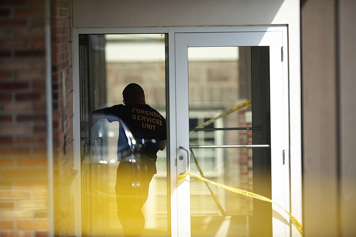 An officer investigates a shooting that occurred in the Masontown borough municipal center on Wednesday, September 19, 2018, in Masontown, Pa. A gunman opened fire outside a crowded courtroom Wednesday afternoon, shooting at police and others before an officer fired multiple shots at him, killing him. (Andrew Stein/Post-Gazette via AP)