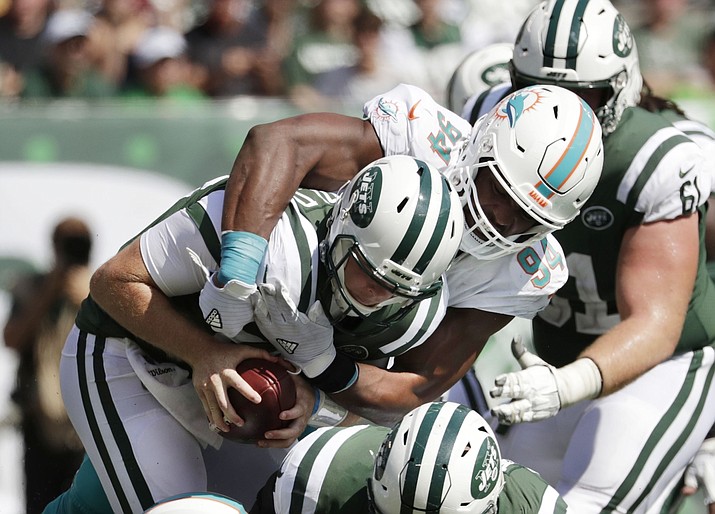 In this Sept. 16, 2018, file photo, Miami Dolphins' Robert Quinn (94) sacks New York Jets' Sam Darnold (14) during the first half of an NFL football game in East Rutherford, N.J. The Oakland Raiders play the Dolphins this week. "The addition of Quinn is huge," says Raiders coach Jon Gruden. "He has given them supreme effort opposite Cameron Wake. And they have a very good unit inside that can generate pressure as well. It's a combination of new players, new energy and the scheme. It's fun to watch them." (Julio Cortez/AP, File)


