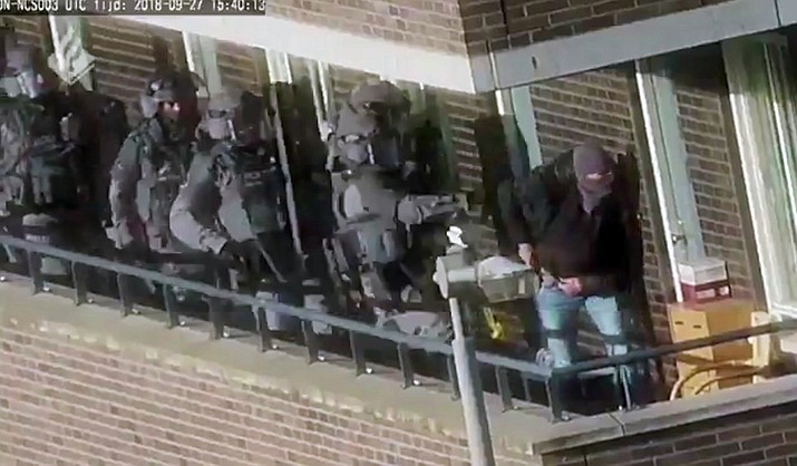In this image made from video provided by the Netherlands Police, armed police prepare for an operation in a residential area in Arnhem, Netherlands, Thursday, Sept. 27, 2018. Seven men were arrested Thursday in the Netherlands on suspicion of plotting a large-scale extremist attack that Dutch prosecutors said they think was foiled following a months-long investigation. The national prosecutor's office said in a statement that heavily armed police arrested the men in the towns of Arnhem, about 100 kilometers (62 miles) south of Amsterdam, and Weert in the southern Netherlands close to the borders of Germany and Belgium. (Netherlands Police via AP)