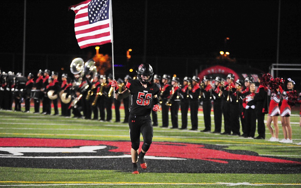 Bradshaw Mountain's Seth Johnson brings out the American Flag before they take on the Flagstaff Eagles Friday, Sept. 28, 2018 in Prescott Valley. (Les Stukenberg/Courier)