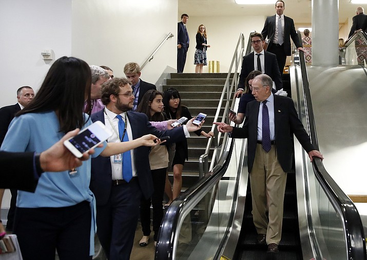 Senate Judiciary Committee Chairman Chuck Grassley, R-Iowa, talks with reporters as he uses the escalator on Capitol Hill, Wednesday, Oct. 3, 2018 in Washington. (AP Photo/Alex Brandon)