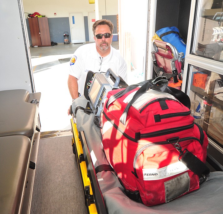 Lifeline Ambulance Operations supervisor Alex Price demonstrates unloading a gurney from an ambulance at the company headquarters in Prescott Wednesday, Aug. 1, 2018. (Les Stukenberg/Courier)