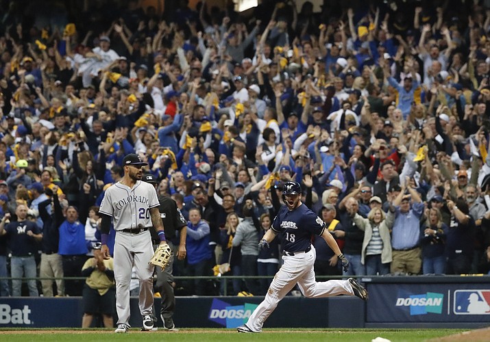 Milwaukee Brewers' Mike Moustakas hits a walk off RBI single during the 10th inning of Game 1 of the National League Divisional Series baseball game against the Colorado Rockies Thursday, Oct. 4, 2018, in Milwaukee. The Brewers won 3-2 to take a 1-0 lead in the series. (Jeff Roberson/AP)