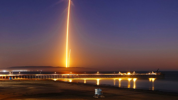 Two streaks in this long exposure photo show a SpaceX Falcon 9 rocket lifting off, left, from Vandenberg Air Force Base, as seen from Pismo Beach, Calif. Sunday, Oct. 7, 2018, and then its first stage returning, right, to Earth at a nearby landing pad. The primary purpose of the mission was to place the SAOCOM 1A satellite into orbit, but SpaceX also wanted to expand its recovery of first stages to its launch site at the Air Force base, about 130 miles (209 kilometers) northwest of Los Angeles. (Joe Johnston/The Tribune (of San Luis Obispo) via AP)