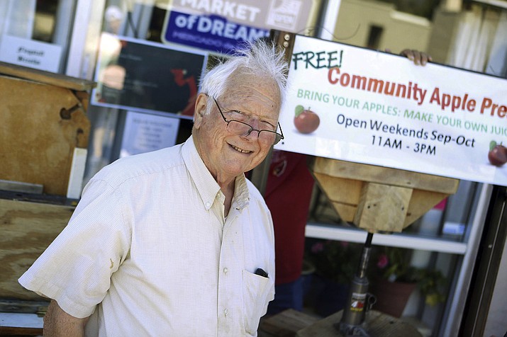 In this Sept. 29, 2018, photo Resident Ward Davis spends every Saturday and Sunday process apples for free for local community members with his apple press at the Market of Dreams Sunnyside Community Market on 7th Street in Flagstaff, Ariz. The Flagstaff area didn't have its usual late frost this year so the result, months later, is a bountiful apple harvest. (Ben Shanahan/Arizona Daily Sun via AP)