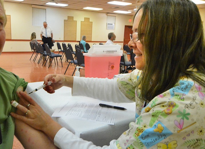 Yavapai County nurse Christine Dixon gives a flu shot in the Verde Village Clubhouse Wednesday. VVN/Vyto Starinskas