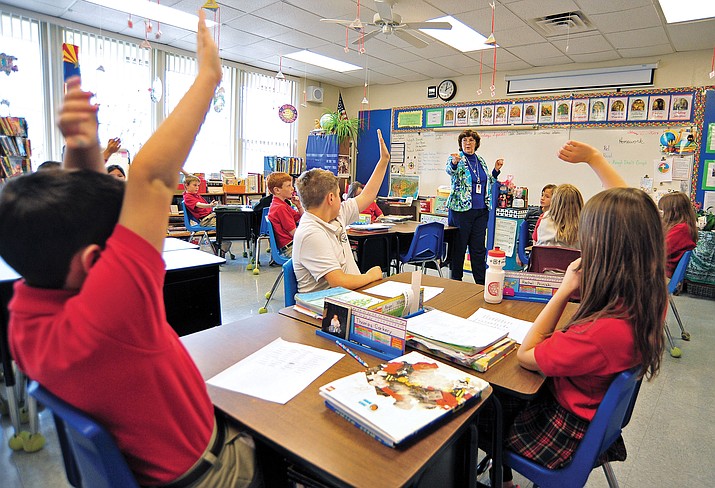 Sister Terri Stafford, I.B.V.M., asks a question from her 4th grade students about the civil rights movement during a history lesson while students, from left, Thomas Corkery, Angel Morado, and Rachel Priniski raise their hands to answer, at Sacred Heart Catholic School in Prescott. (Courier file photo)